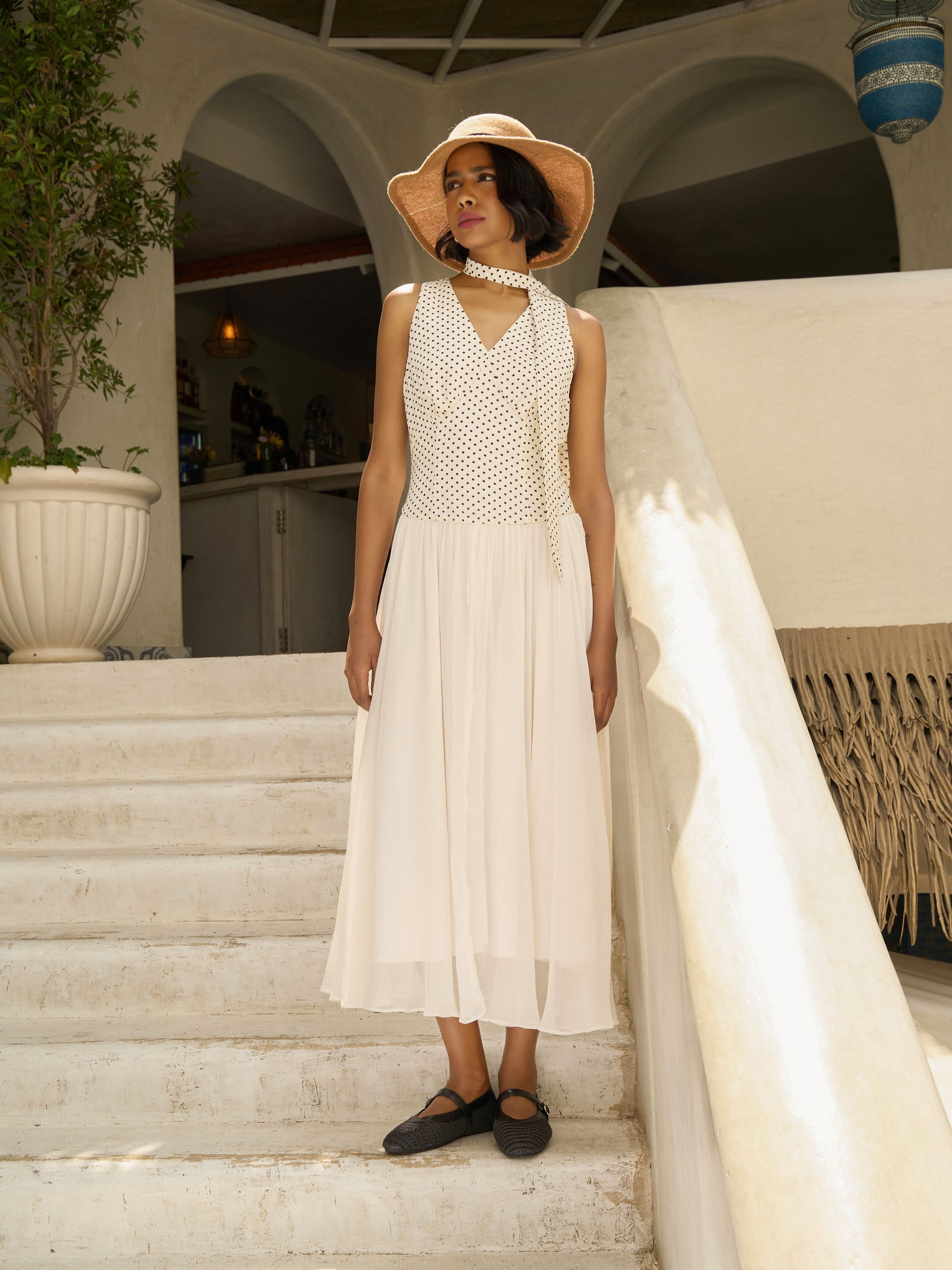 Front view of model wearing Apricot white midi dress with polka dot bodice, pleated skirt, and neck scarf-MISSVI