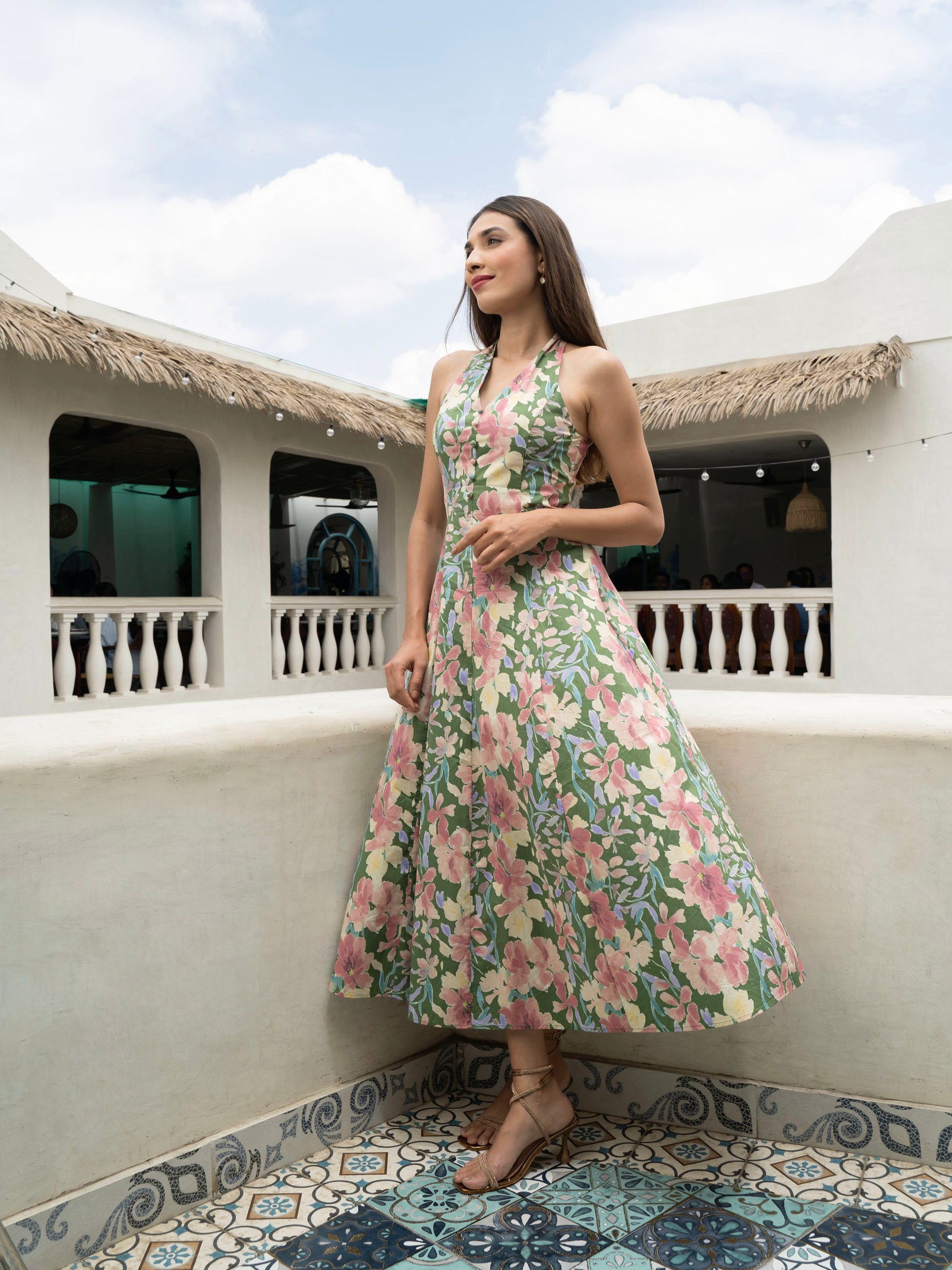 Side view of model wearing Hibiscus floral halter midi with covered buttons, open back, and fit-and-flare silhouette-MISSVI