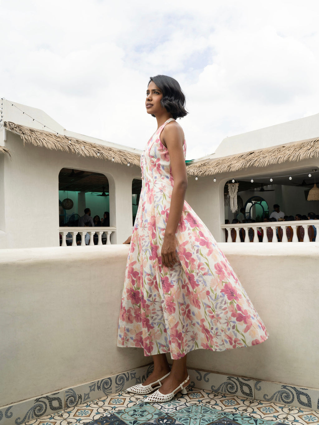 Side view of model wearing Pastel floral halter midi with covered buttons, open back, and fit-and-flare silhouette-MISSVI