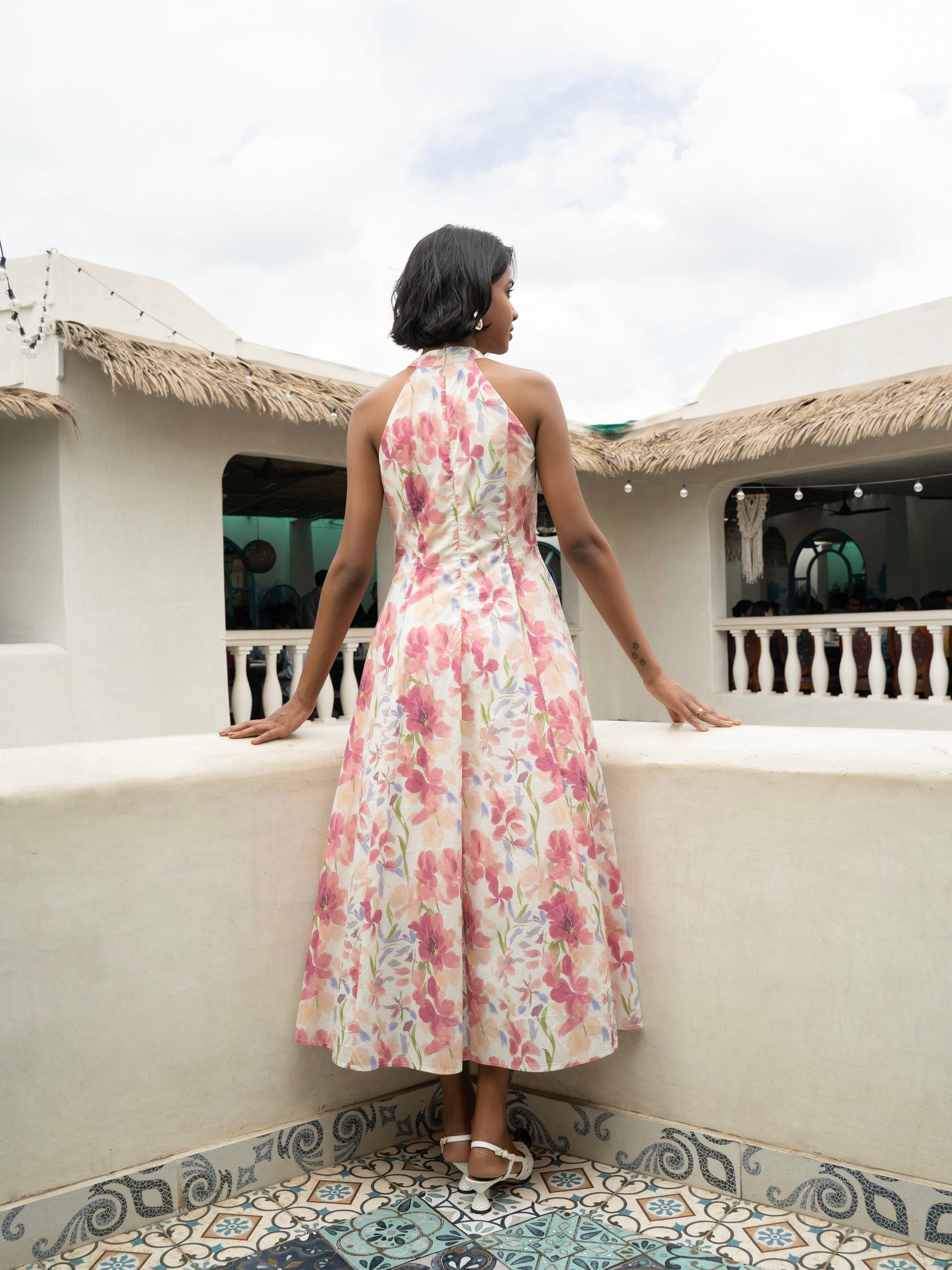 Rear view of model wearing Pastel floral halter midi with covered buttons, open back, and fit-and-flare silhouette-MISSVI