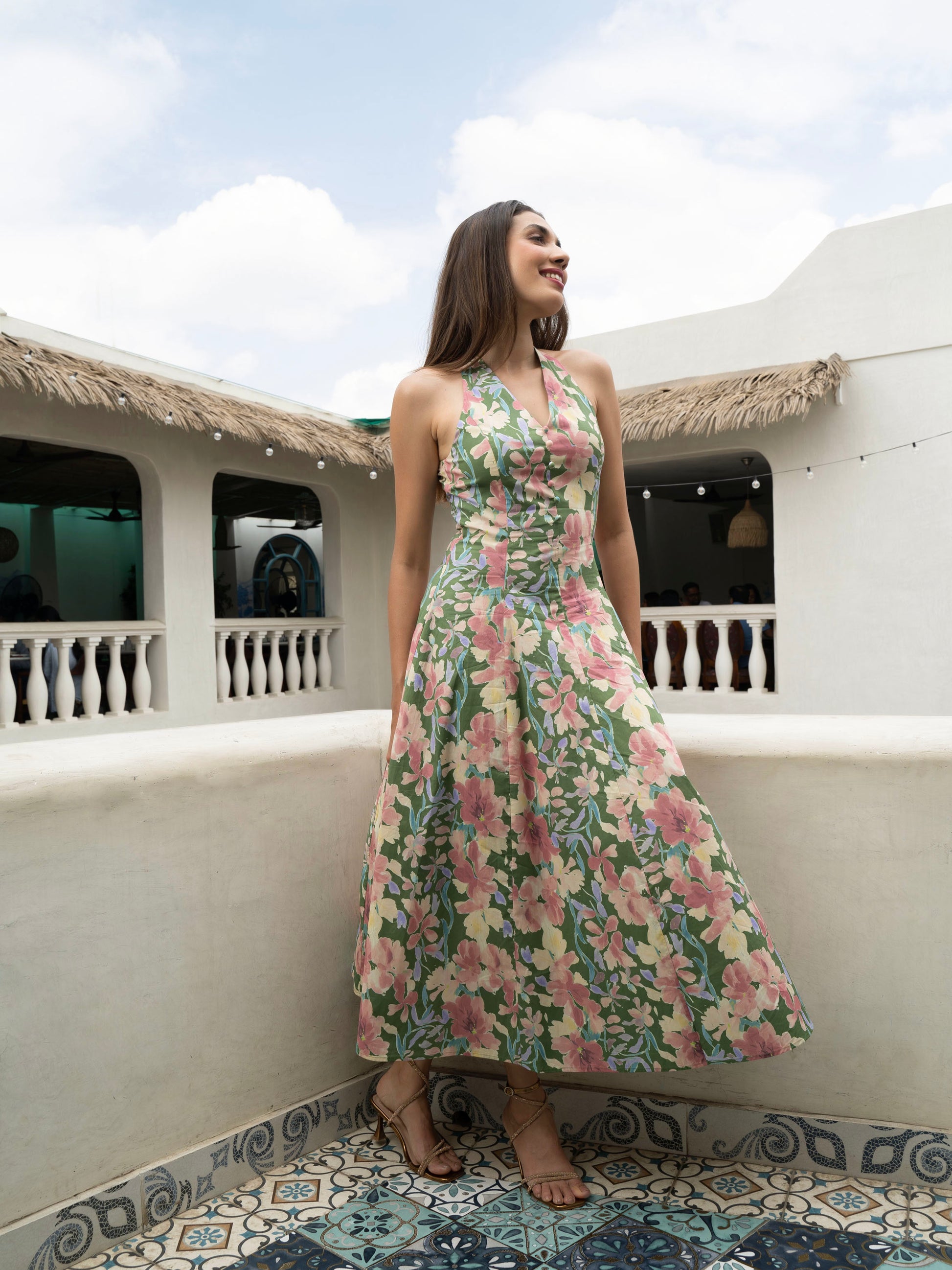 Side view of model wearing Hibiscus floral halter midi with covered buttons, open back, and fit-and-flare silhouette-MISSVI