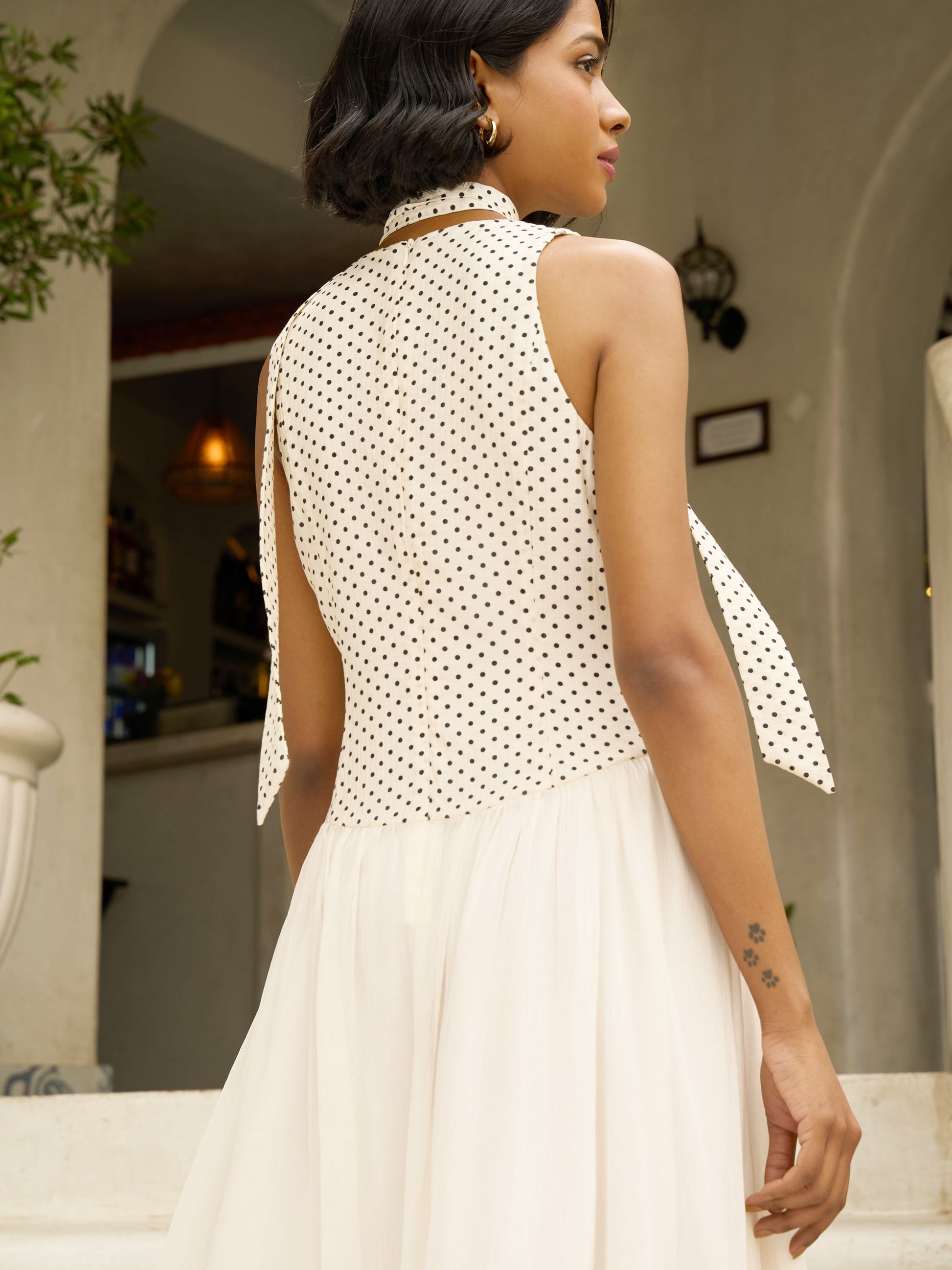 Close up rear view of model wearing Apricot white midi dress with polka dot bodice, pleated skirt, and neck scarf-MISSVI