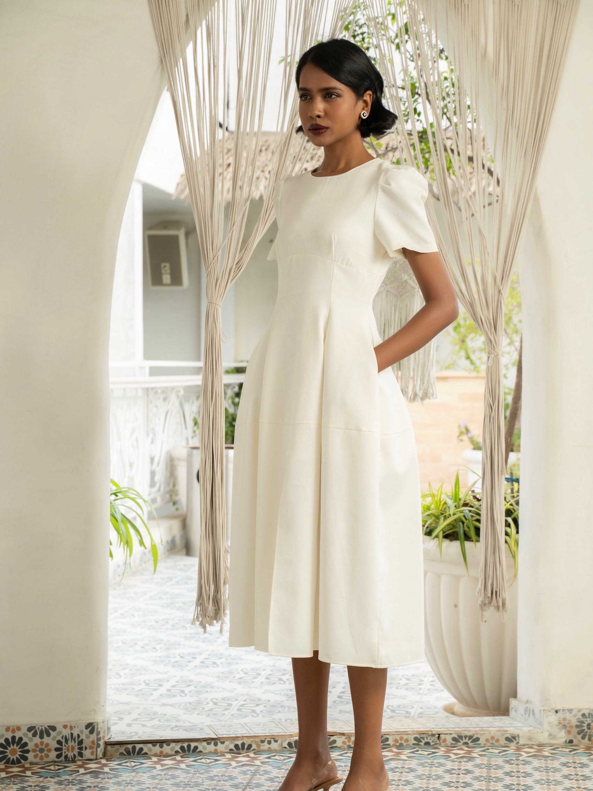 Side view of model wearing Ivory white midi dress with front slit, puffed sleeve-MISSVI