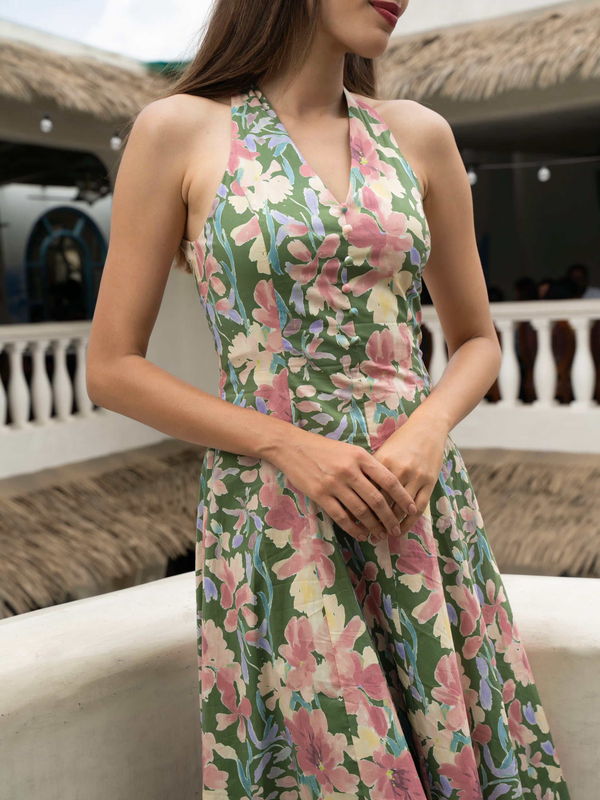 Close up front view of model wearing Hibiscus floral halter midi with covered buttons, open back, and fit-and-flare silhouette-MISSVI