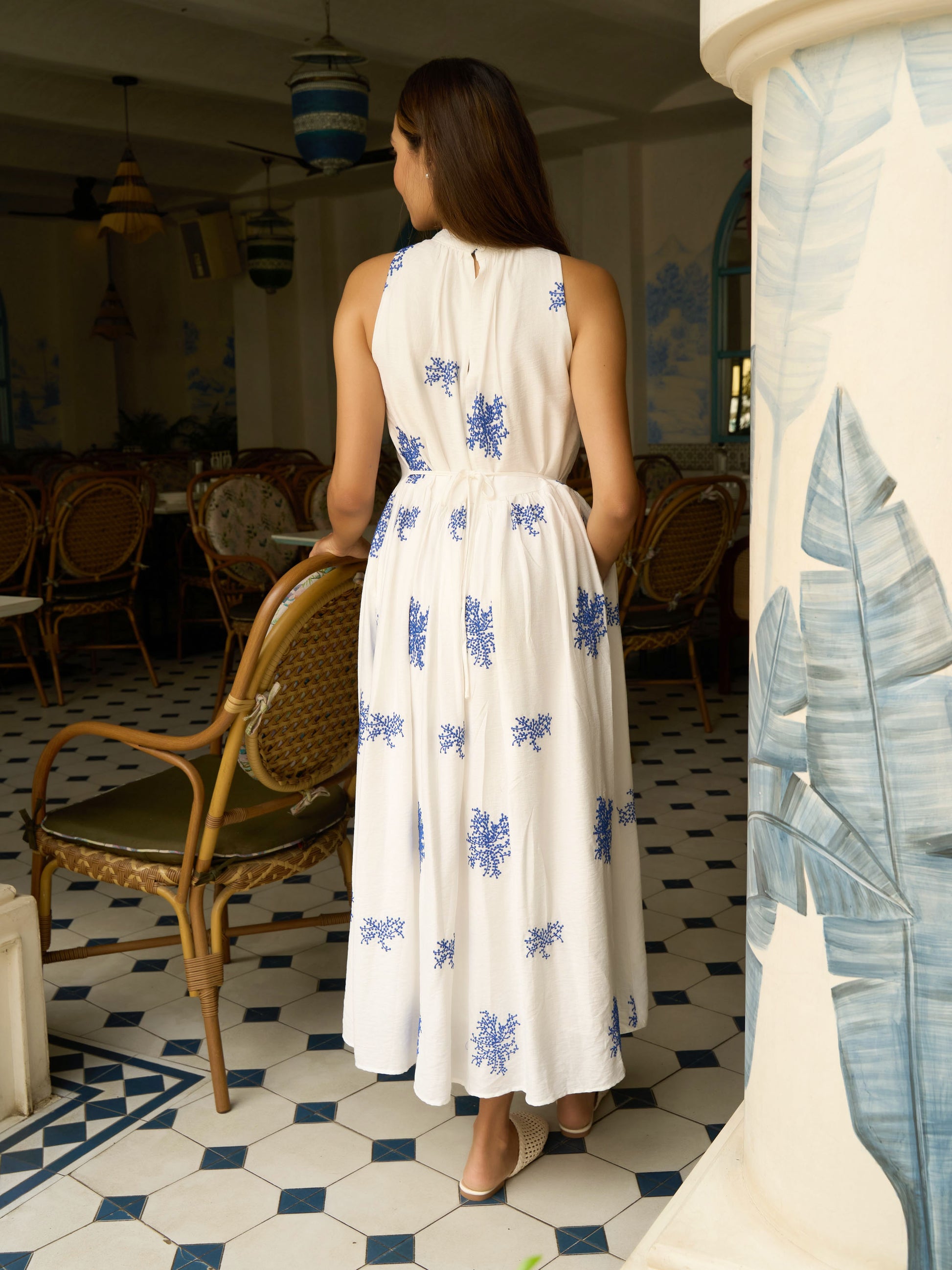 Rear view of model wearing Embroidered sleeveless maxi in cotton-silk with halter neck, tie-back waist, and pockets-MISSVI