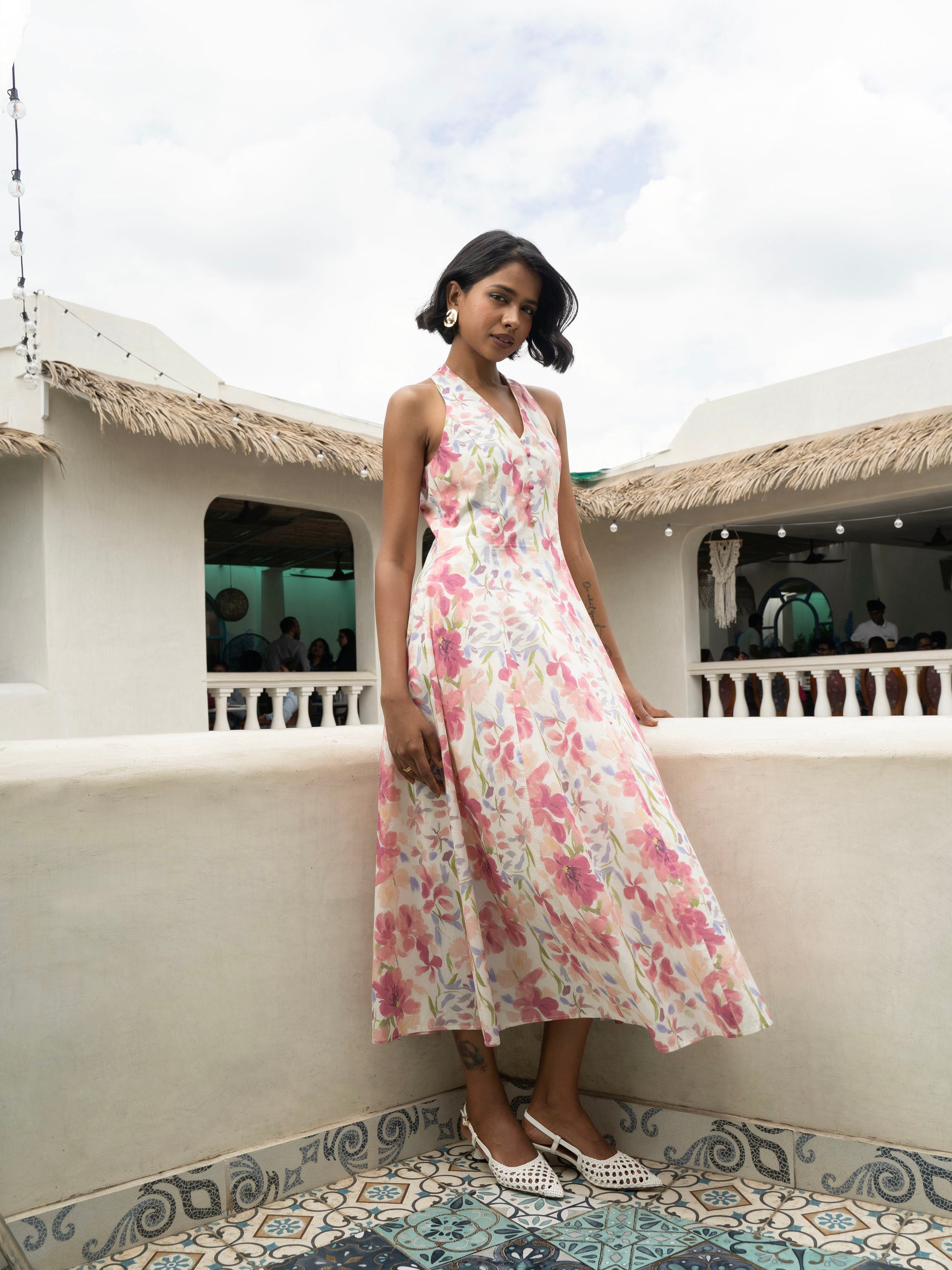Side view of model wearing Pastel floral halter midi with covered buttons, open back, and fit-and-flare silhouette-MISSVI