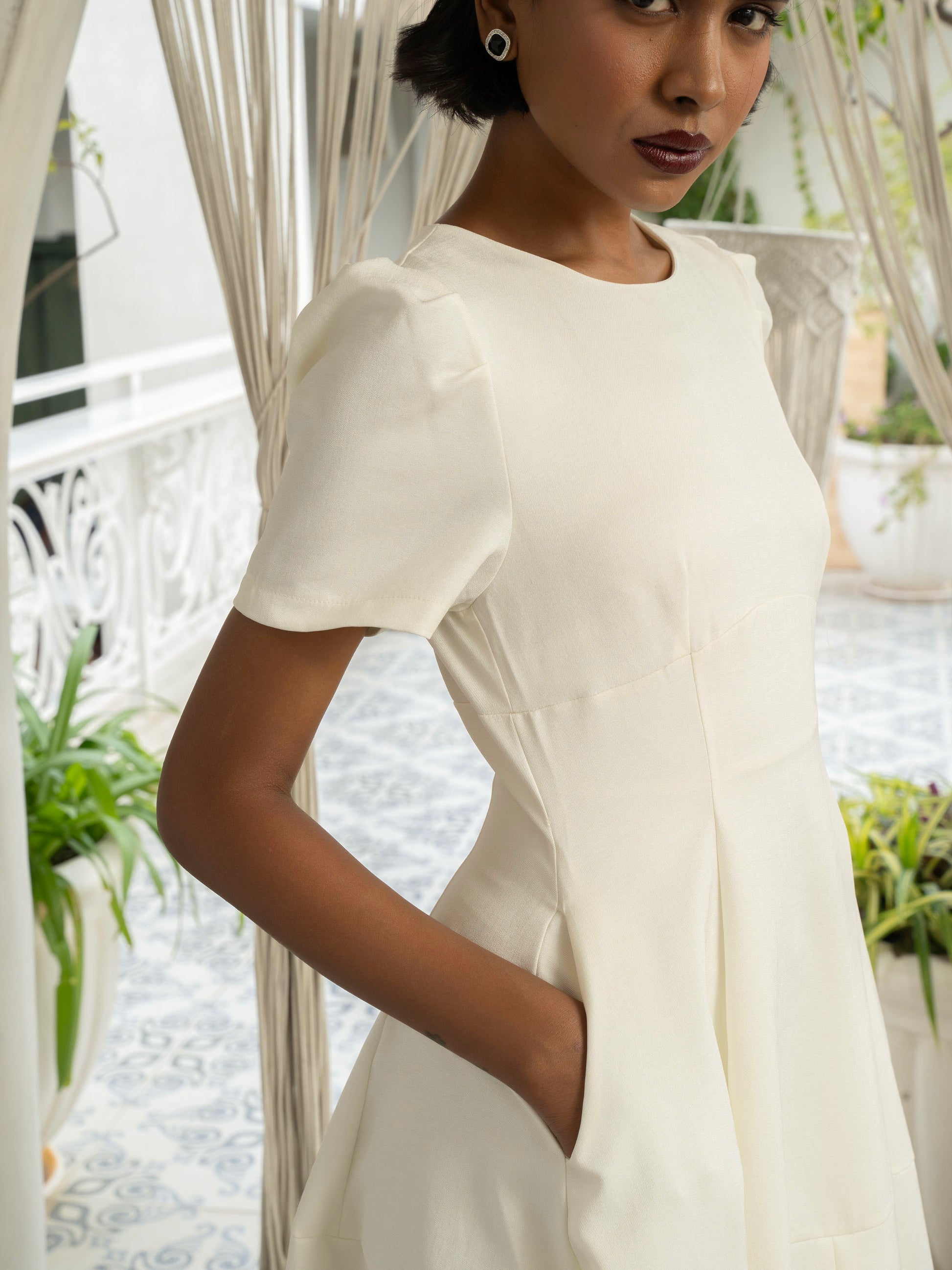 Side close up view of model wearing Ivory white midi dress with front slit, puffed sleeve-MISSVI