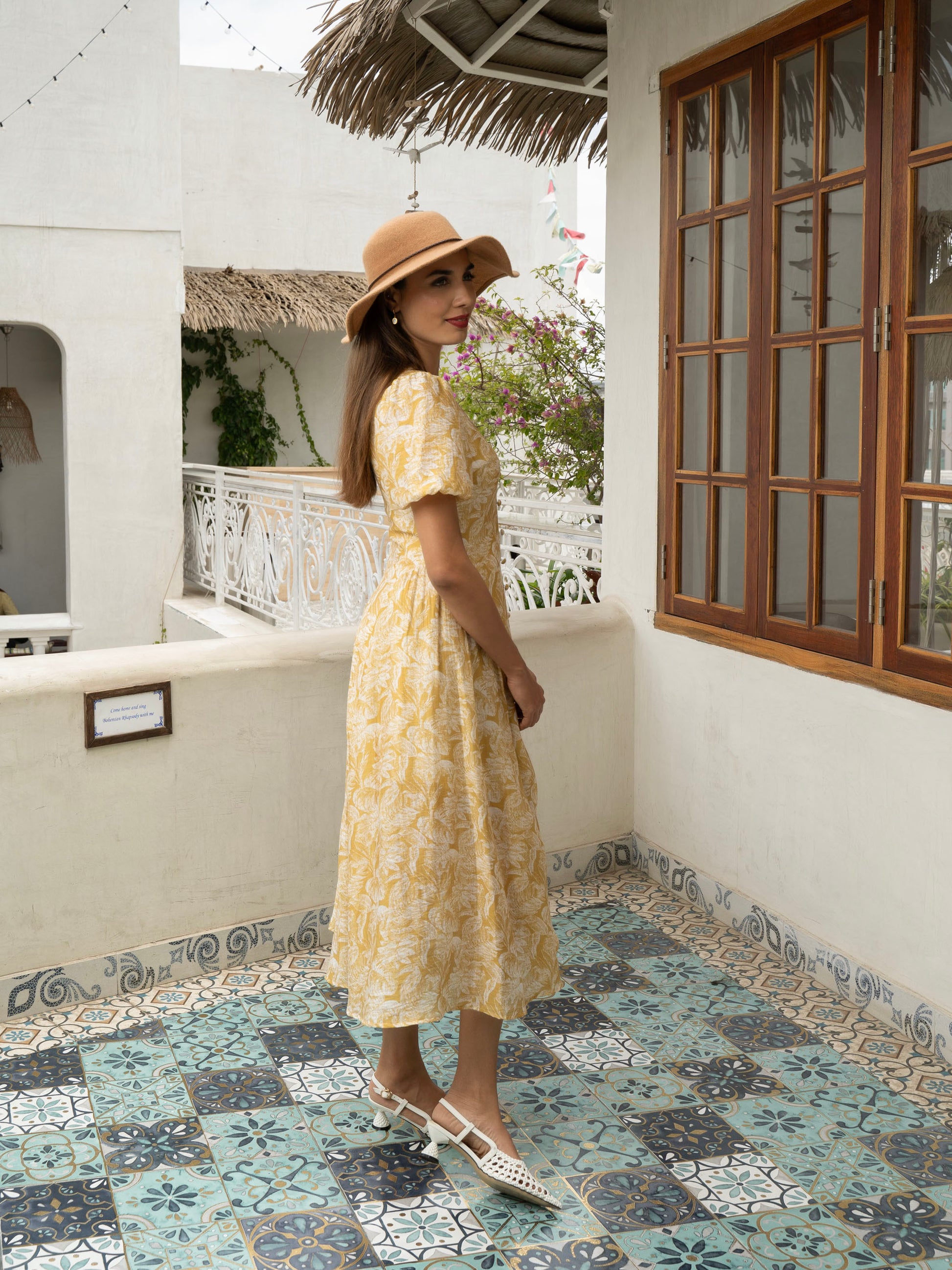 Side view of model wearing yellow Floral fit-and-flare midi with puff sleeves, covered buttons, and V-neckline-MISSVI